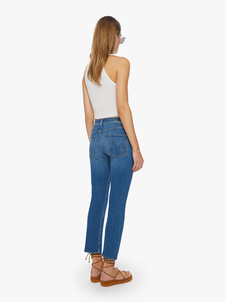 Back view of a woman mid-rise straight-leg jeans with an ankle-length inseam and a clean hem in a mid-blue wash.
