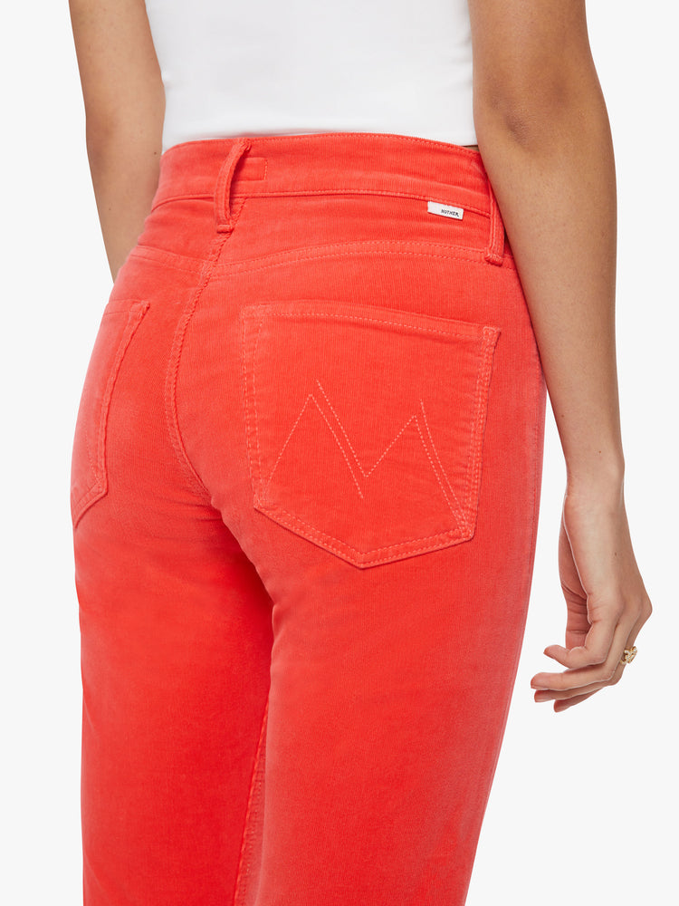 Close up back view of a woman mid-rise straight leg with an ankle-length inseam and a clean hem in a bright orange-red hue corduroy fabric.