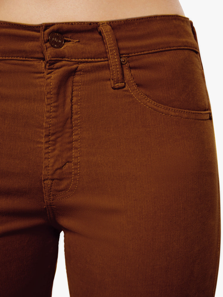 Close up waist view of a woman mid-rise straight leg with an ankle-length inseam and a clean hem in a maroon-brown hue.