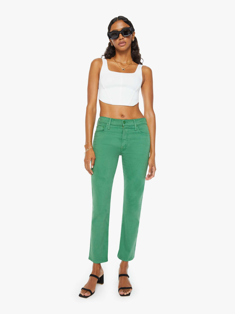 Front view of a woman in green straight-leg pants with tonal hardware and styled in a white tank top.