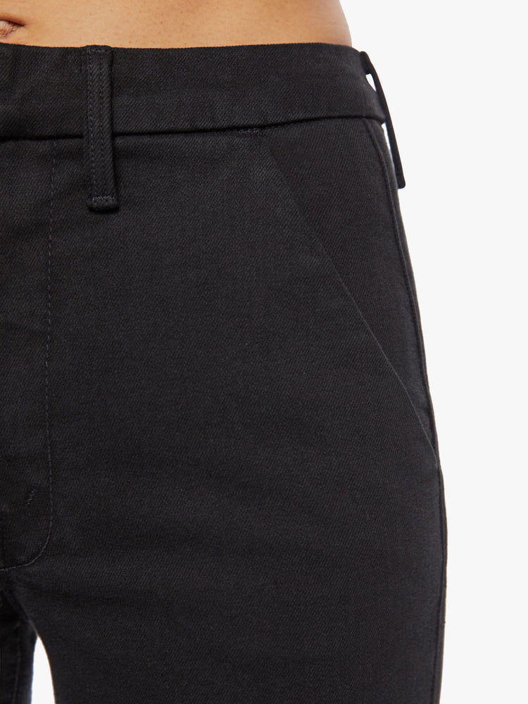 Waist close up view of a woman high-waisted wide leg pant features back slit pockets, a 34-inch inseam and a clean hem in a solid black hue.