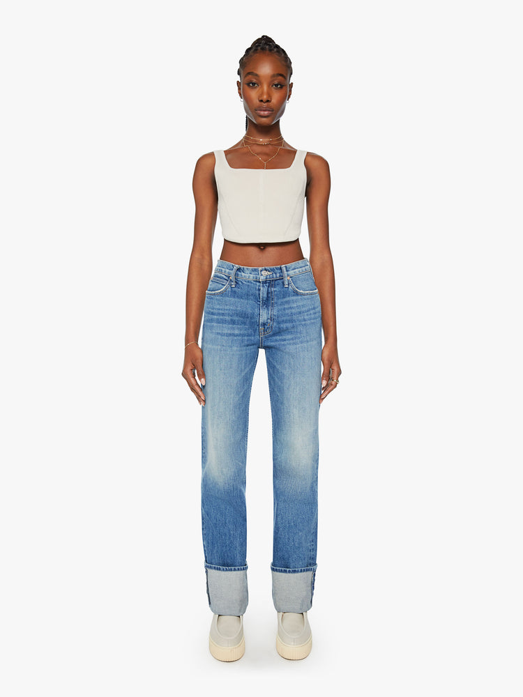Front view of a woman straight-leg jean with a high rise and a 29-inch inseam with a thick folded hem in mid blue wash. 