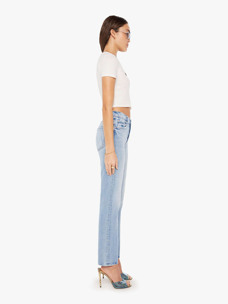 Side view of a woman high-rise jeans with a narrow straight leg and a 31-inch inseam with a clean hem in a light blue wash.
