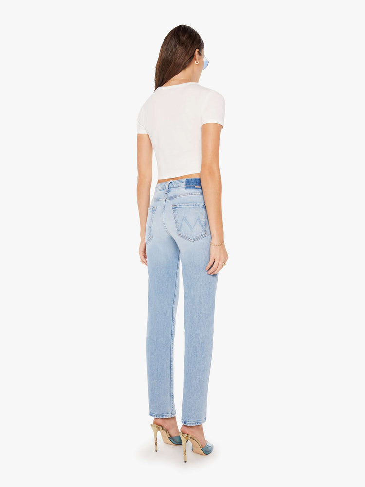 Back view of a woman high-rise jeans with a narrow straight leg and a 31-inch inseam with a clean hem in a light blue wash.