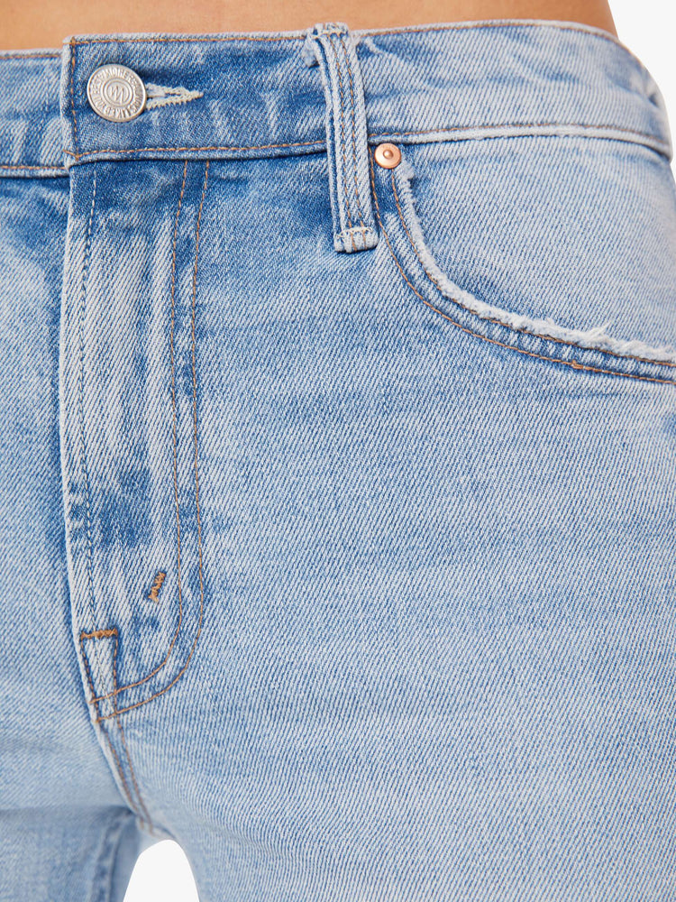Swatch view of a woman high-rise jeans with a narrow straight leg and a 31-inch inseam with a clean hem in a light blue wash.
