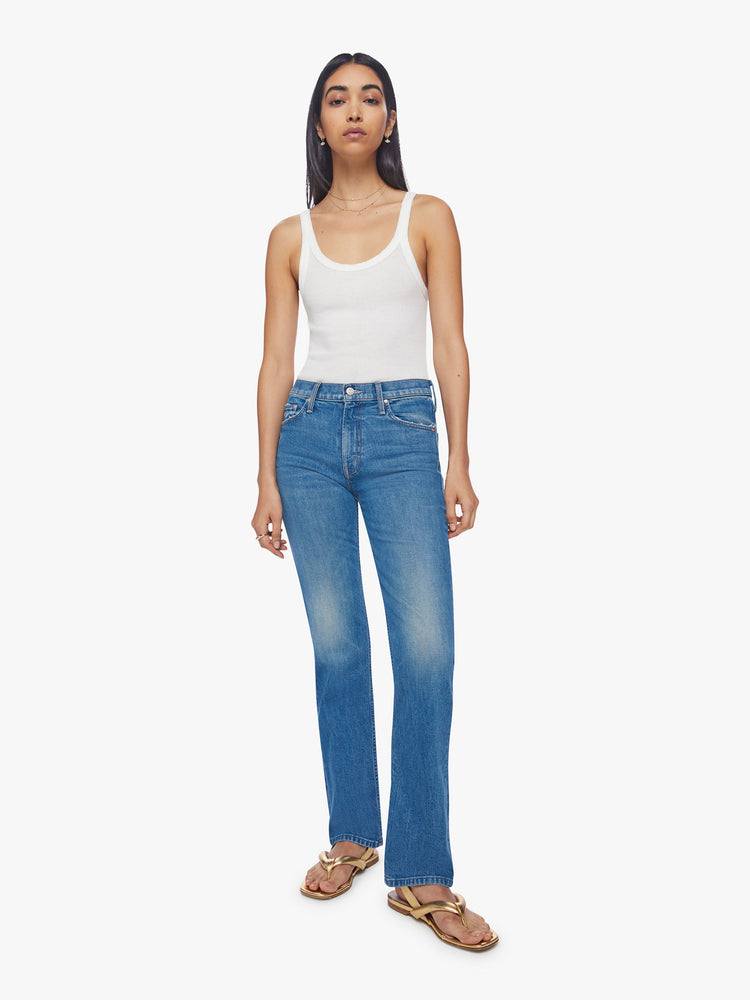 Front view of a woman high-rise jeans with a narrow straight leg and a 31-inch inseam with a clean hem in a mid-blue wash.