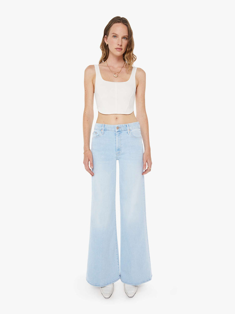Front view of a woman in a wide-leg jeans with a mid rise, 32-inch inseam and a clean hem in a light blue wash.