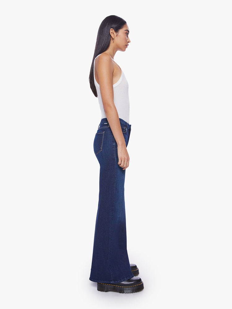 Side view of a woman wide leg jeans with a high rise, 32-inch inseam and a clean hem in a dark blue wash.