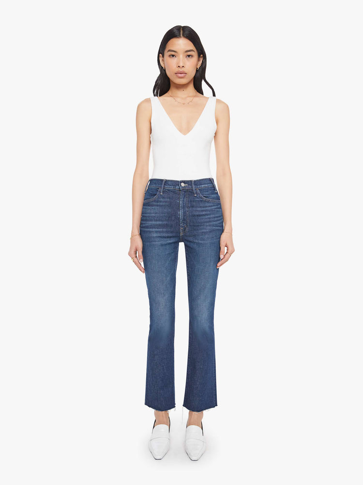 Front view of a woman in a  high-rise flare has a zip fly, 28.25-inch inseam and a frayed hem.