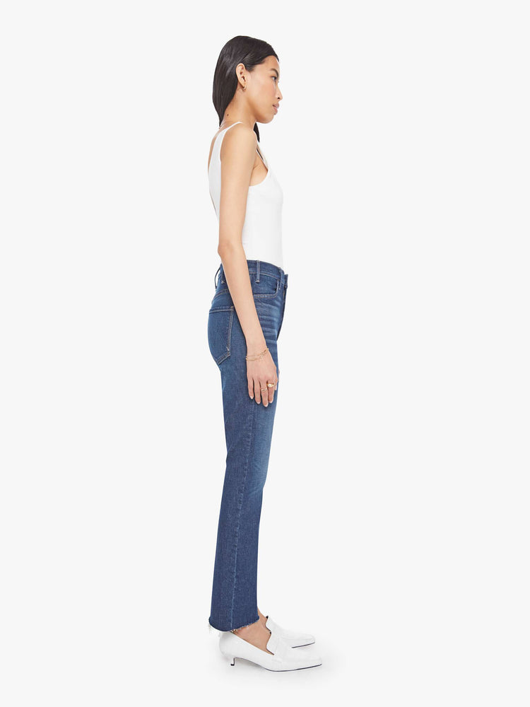 Side view of a woman in a  high-rise flare has a zip fly, 28.25-inch inseam and a frayed hem.