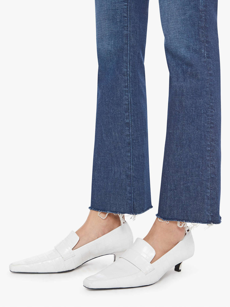 Hem close up view of a woman in a  high-rise flare has a zip fly, 28.25-inch inseam and a frayed hem.