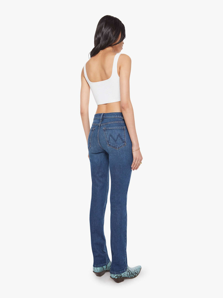 Back view of a woman in a dark mid-rise straight leg jean with a zip fly, long 31-inch inseam and a clean hem.