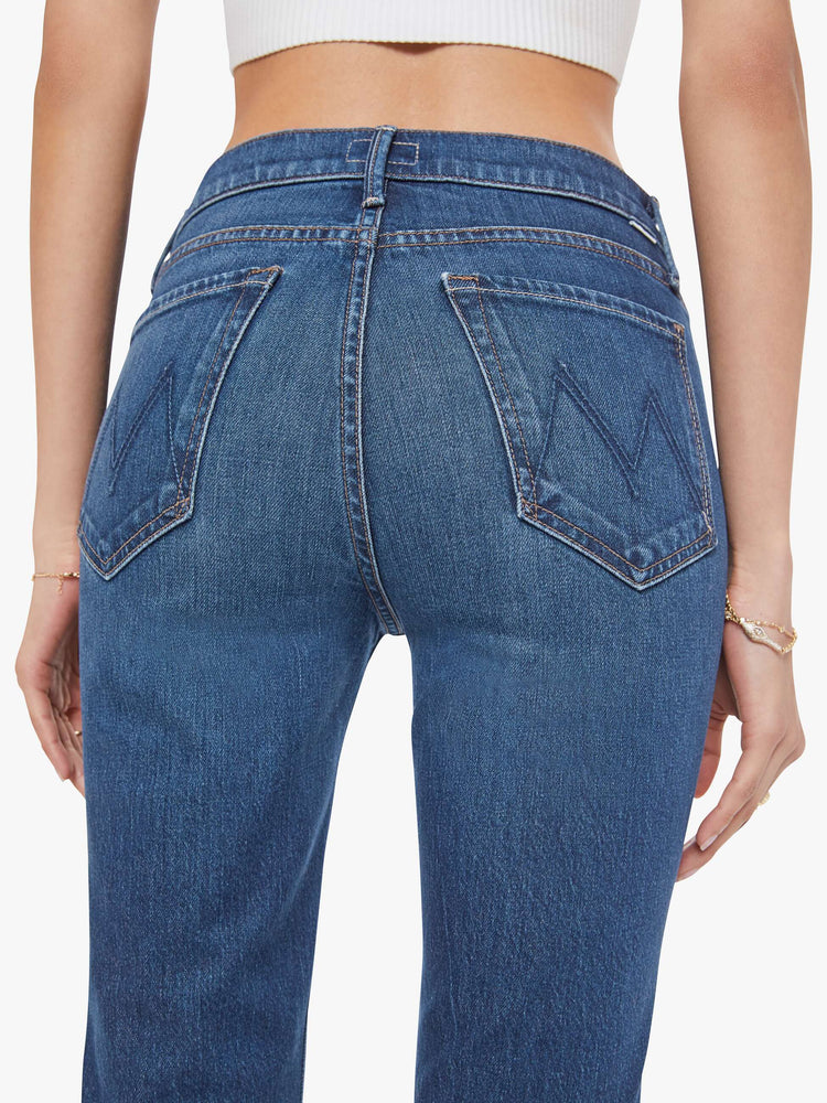 Close up view of a woman in a dark mid-rise straight leg jean with a zip fly, long 31-inch inseam and a clean hem.