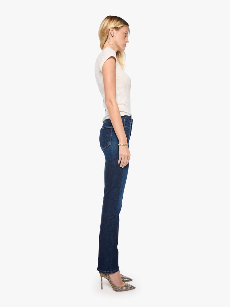 Side view of a woman in dark blue mid-rise straight-leg with a zip fly, long 31-inch inseam and a clean hem.
