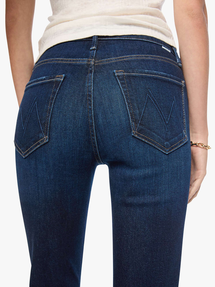 Close up view of a woman in dark blue mid-rise straight-leg with a zip fly, long 31-inch inseam and a clean hem.