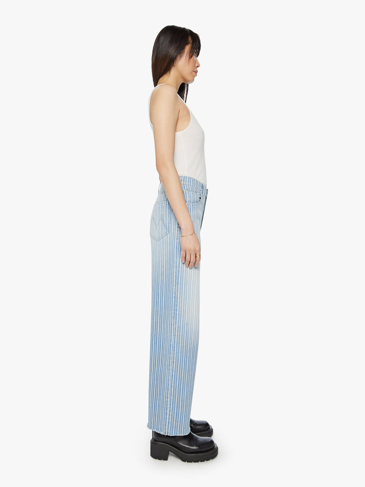 Side view of a woman super high rise jean with a loose wide leg, zip fly and a 31-inch inseam with a clean hem in a light blue and white striped denim.