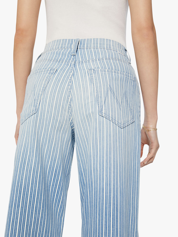 Close back view of a woman super high rise jean with a loose wide leg, zip fly and a 31-inch inseam with a clean hem in a light blue and white striped denim.