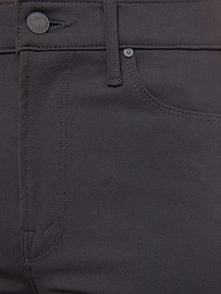 Swatch view of a woman in a black high-rise flared trouser with a zip fly and a 34-inch inseam with a clean hem.