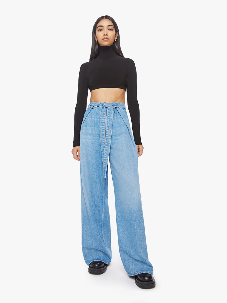 Front view of a woman wide leg jean with super high-rise jeans feature a loose, full leg, a wrapped waist that ties in the front and a long 32-inch inseam in a mid blue wash.