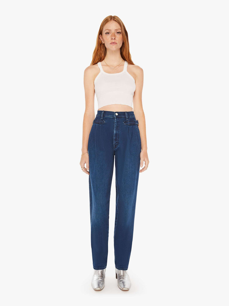 Front view of a woman super high-rise jeans with pleated, adjustable tabs below the waist, side slit pockets, a long 31-inch inseam and a tapered straight leg in a dark blue wash.
