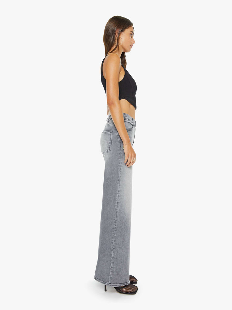 Side view of a woman in grey wide leg pants with a zip fly, high rise, 31-inch inseam and a clean hem.