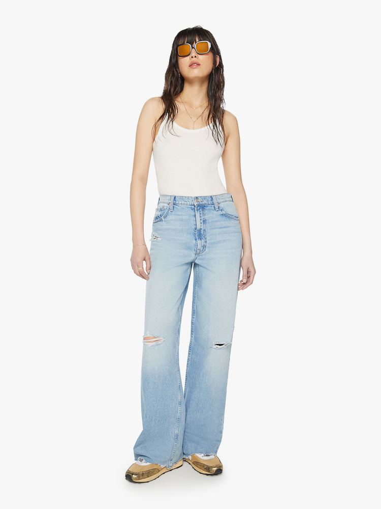 Front view of a woman super high-rise jeans with a loose wide leg, zip fly and a long 32-inch inseam with a chewed back hem in a light blue wash.