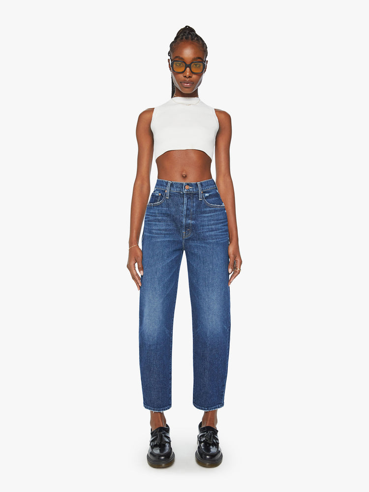 Front view of a woman super high-waisted jeans with a straight barrel leg and a cropped inseam with a clean hem in a dark blue wash.