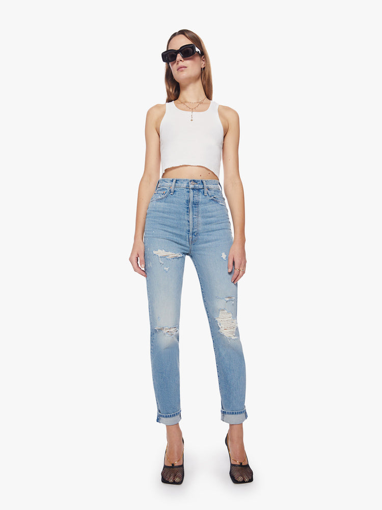 Front view of a woman ultra high-rise jeans with a straight, narrow leg and a cuffed 29-inch inseam in a light blue wash with bleach splatters.