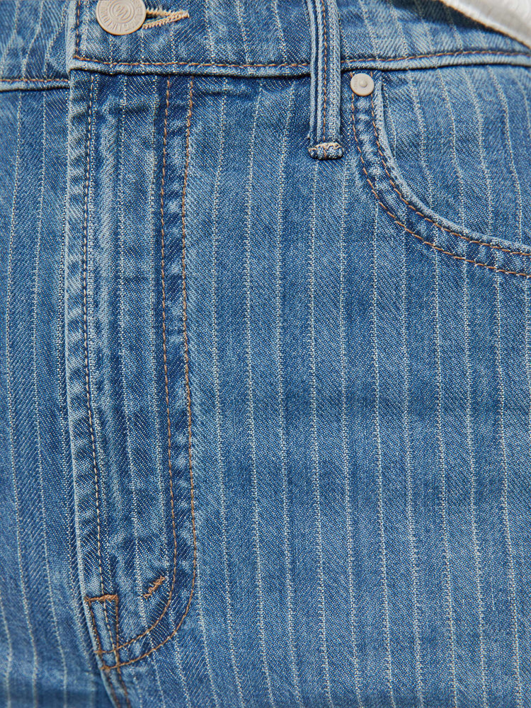 Swatch view of a woman in a mid-blue with Japanese pinstripes in white and fading at the knees wide-leg pant with a zip fly, high rise and a 32-inch inseam with a clean hem.