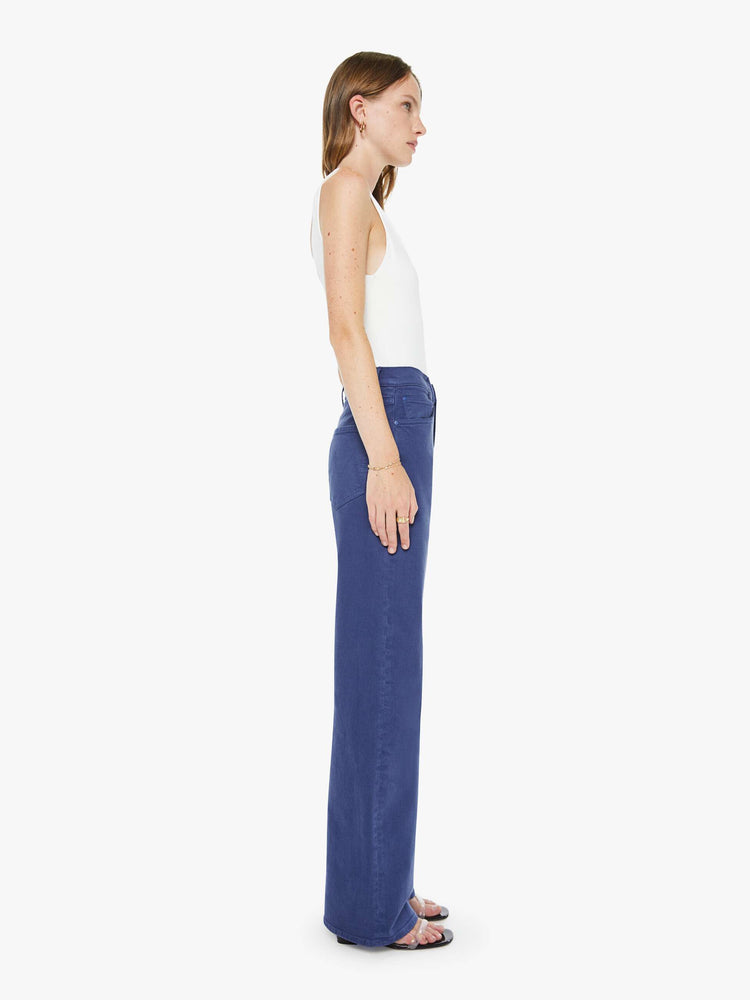 Side view of a woman in navy blue wide-leg pants with a zip fly, high rise and a 32-inch inseam with a clean hem.