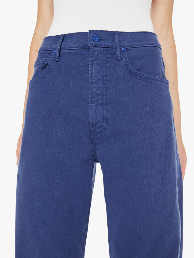Close up view of a woman in navy blue wide-leg pants with a zip fly, high rise and a 32-inch inseam with a clean hem.