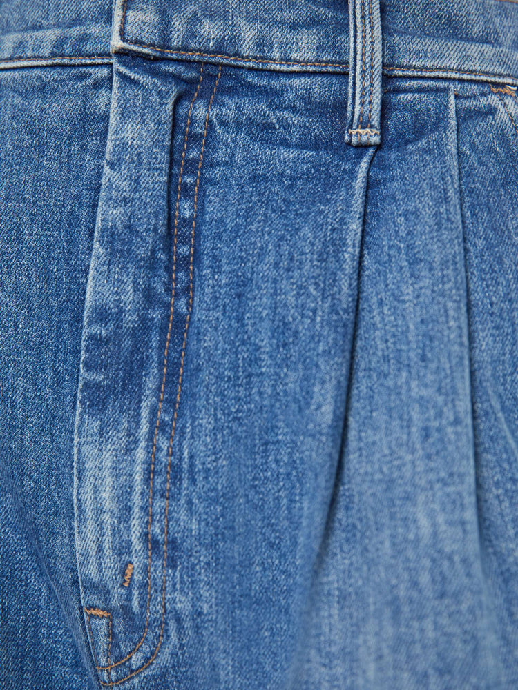 Swatch view of a woman medium blue super high-rise, wide-leg jeans are designed with a pleated waistband, slightly dropped crotch, side slit pockets and a long inseam.