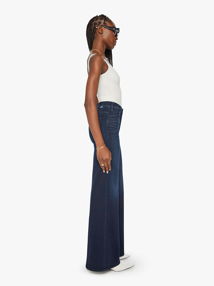 Side view of a woman dark blue wide leg jeans with a high rise, 34-inch inseam and a clean hem.