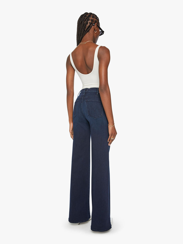 Back view of a woman dark blue wide leg jeans with a high rise, 34-inch inseam and a clean hem.