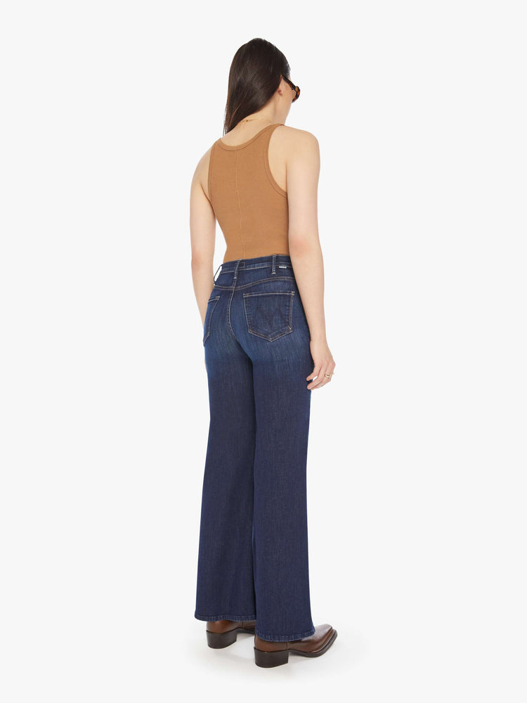 Back view of a woman dark blue wide leg jeans with a high rise, 32-inch inseam and a clean hem.