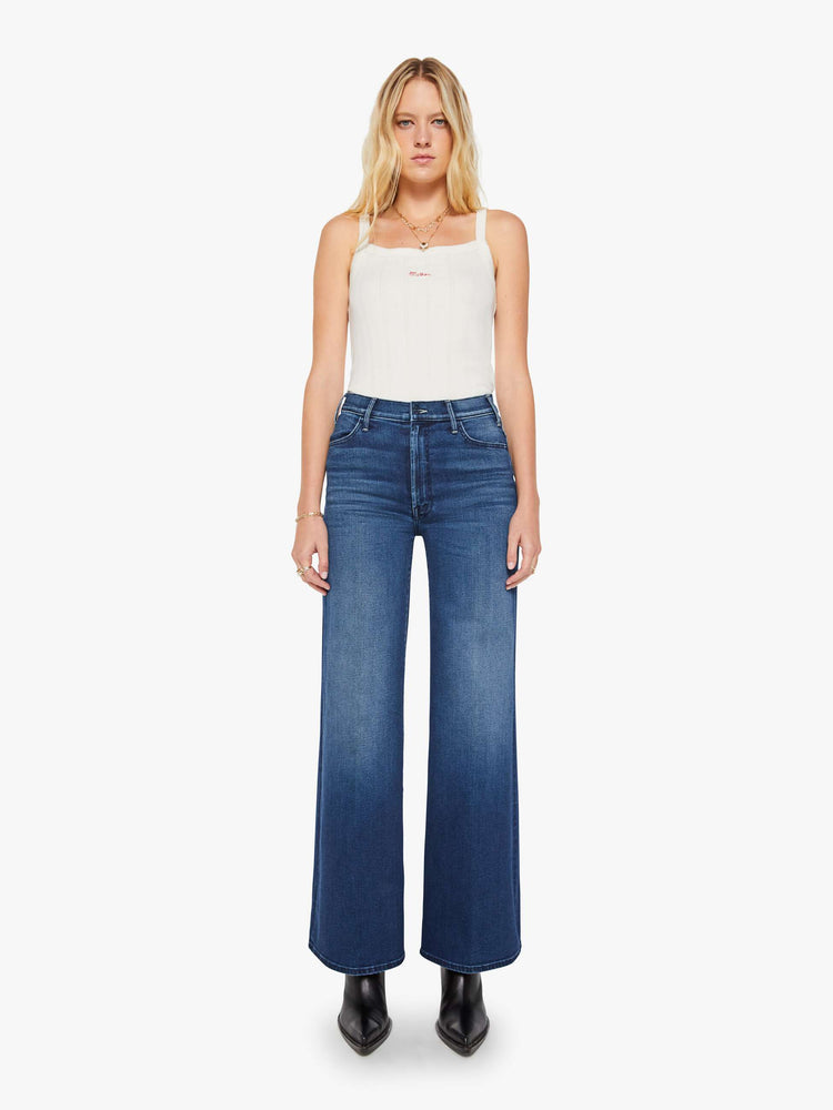Front view of a woman in a dark blue wide leg jean with a high rise, 32-inch inseam and a clean hem.