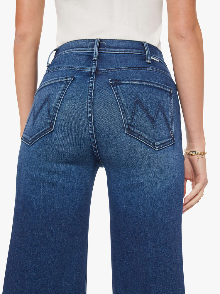 Close up view of a woman in a dark blue wide leg jean with a high rise, 32-inch inseam and a clean hem.