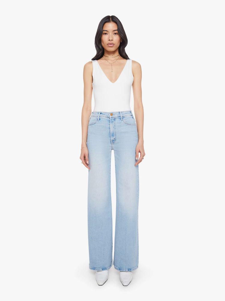 Front view of a woman in a light blue wide leg jeans with a high rise, zip fly, 32-inch inseam and a clean hem.