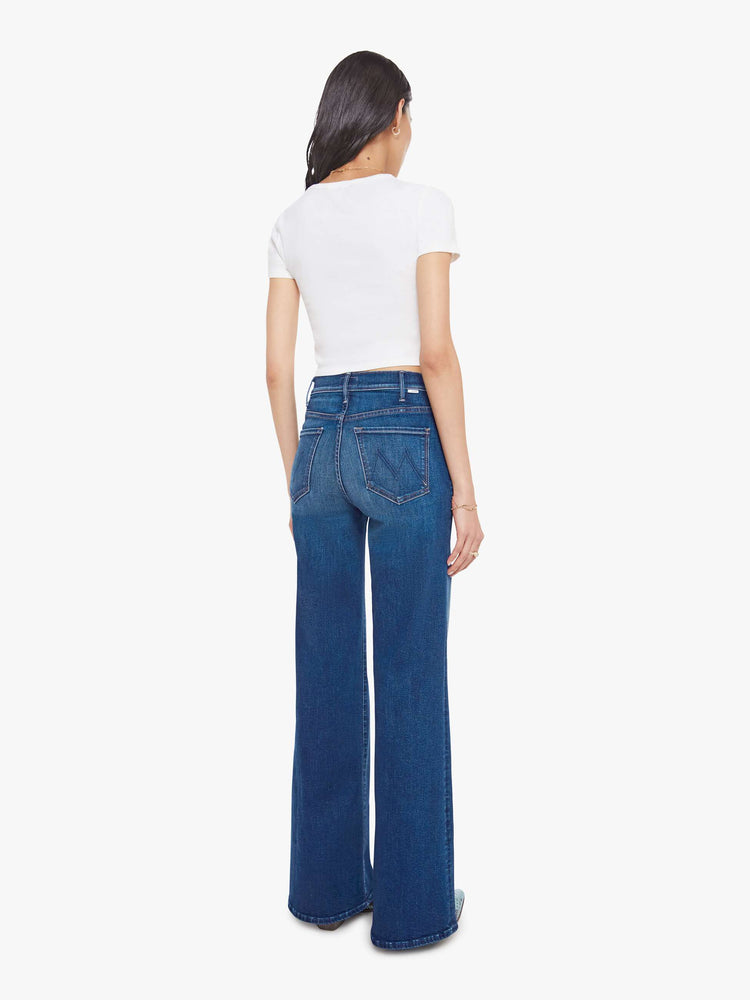 Back view of a woman in a wide leg jeans with a high rise, zip fly, 33.25-inch inseam and a clean hem.