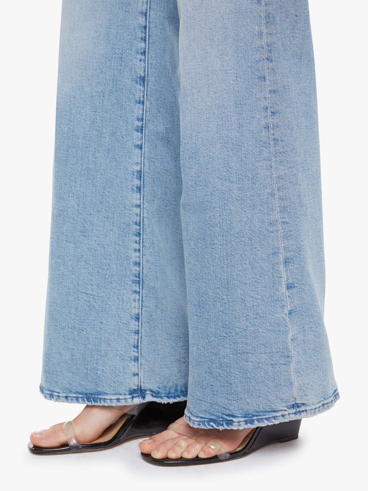 Hem view of a woman in a light blue wide leg jeans with a high rise, zip fly, 32-inch inseam and a clean hem.