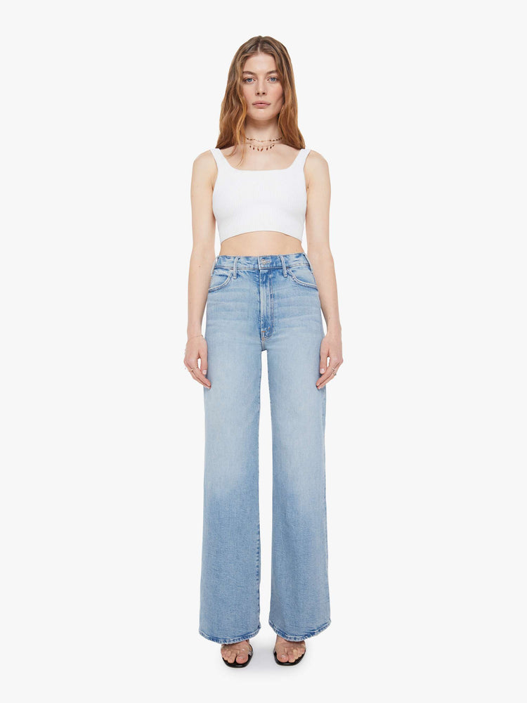 Front view of a woman in a light blue wide leg jeans with a high rise, zip fly, 32-inch inseam and a clean hem.