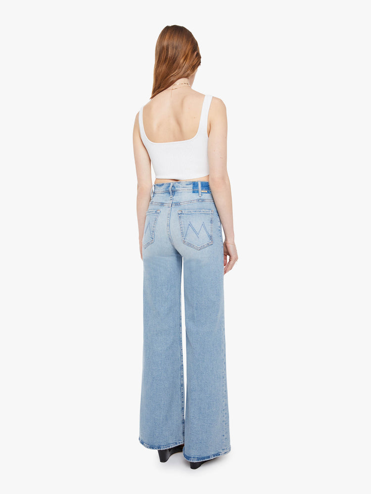 Back view of a woman in a light blue wide leg jeans with a high rise, zip fly, 32-inch inseam and a clean hem.