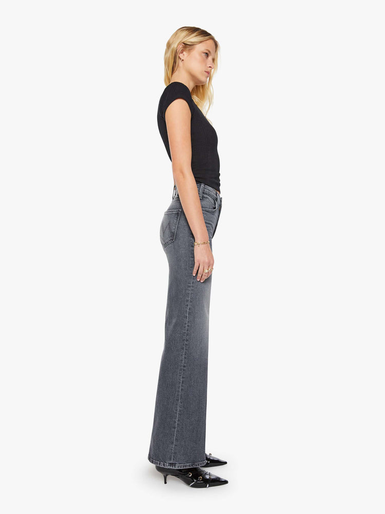 Side view of a woman in faded grey wide leg jeans with a high rise, zip fly, 32-inch inseam and a clean hem.