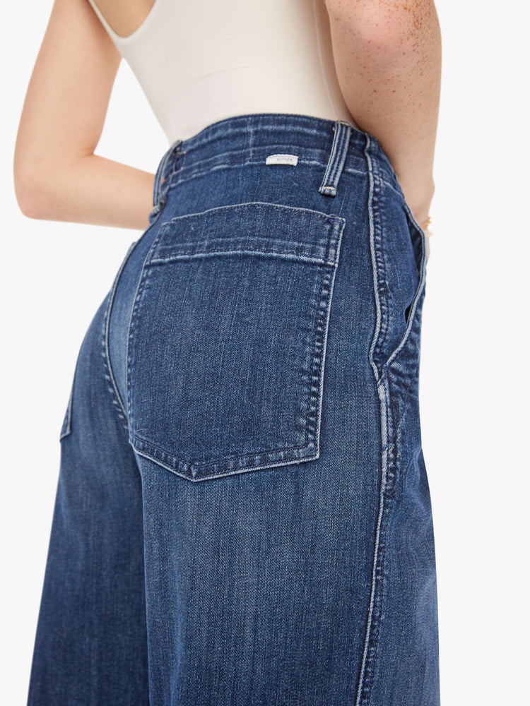 Back close up view of a womens dark blue denim jean featuring a super high rise and wide leg.