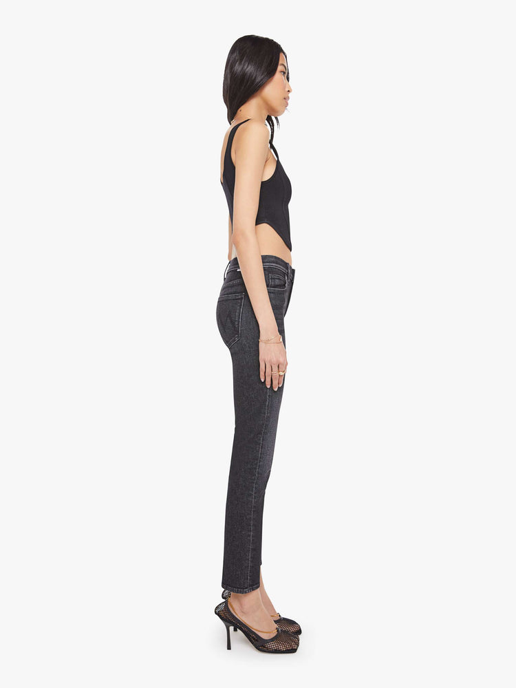 Side view of a woman in washed black  mid-rise straight leg with a zip fly, 28.25-inch inseam and a clean hem. 