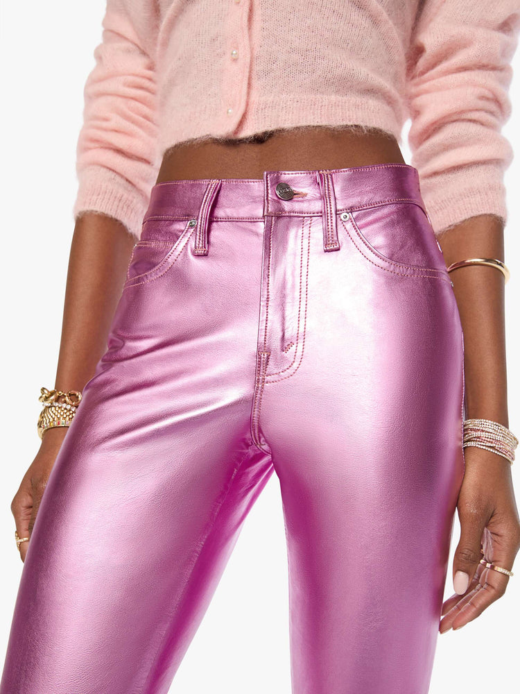 Close up view of a woman in mid-rise straight leg has a zip fly and a 28.25-inch inseam with a clean hem in a metallic faux leather, Hoop Earrings is a reflective light pink.