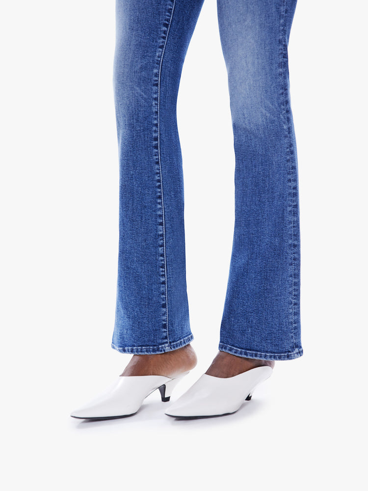 Hem close up view of a woman flare jean with a mid-rise and a long 32-inch inseam with a clean hem in mid-blue wash.