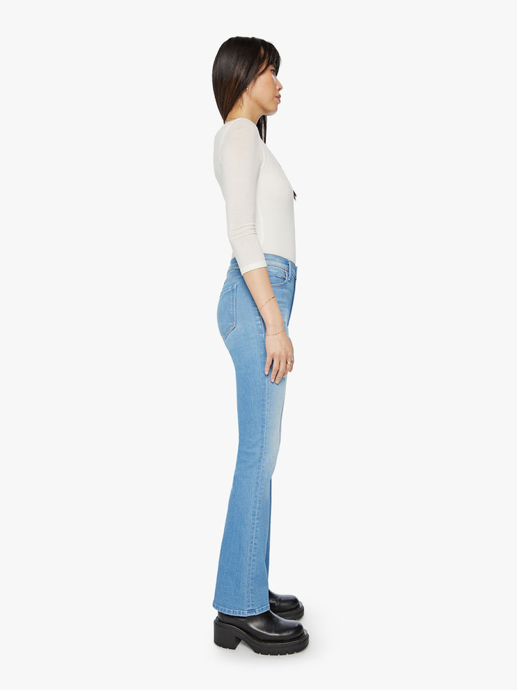 Side view of a narrow flare jeans with a mid rise and a long 32-inch inseam with a clean hem in a light blue wash.