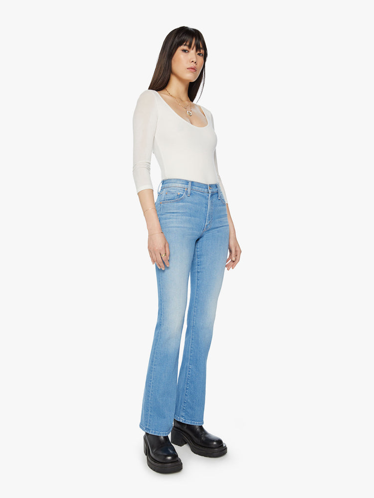 Side angle view of a narrow flare jeans with a mid rise and a long 32-inch inseam with a clean hem in a light blue wash.