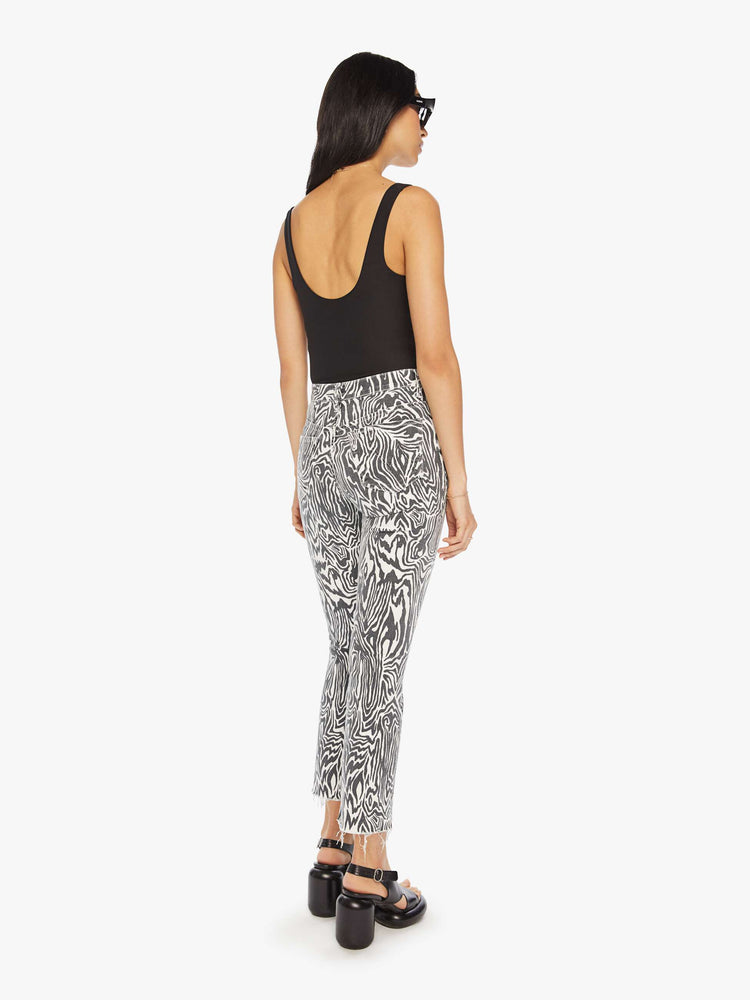Back view of a woman high-rise straight leg with an ankle-length inseam and a frayed hem in a black and white graphic zebra print.